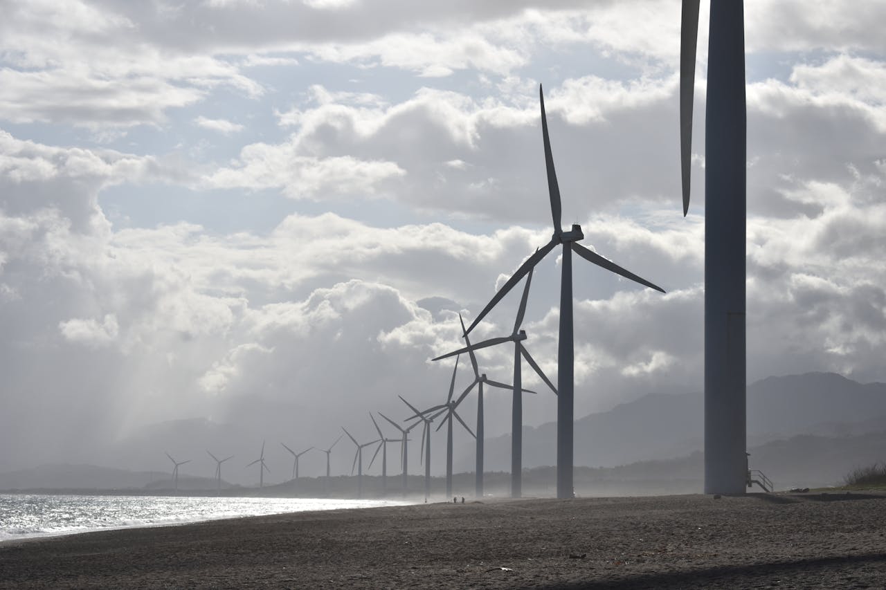 mobile-01 A row of wind turbines along a cloudy beach shoreline in Vigan City, Philippines.